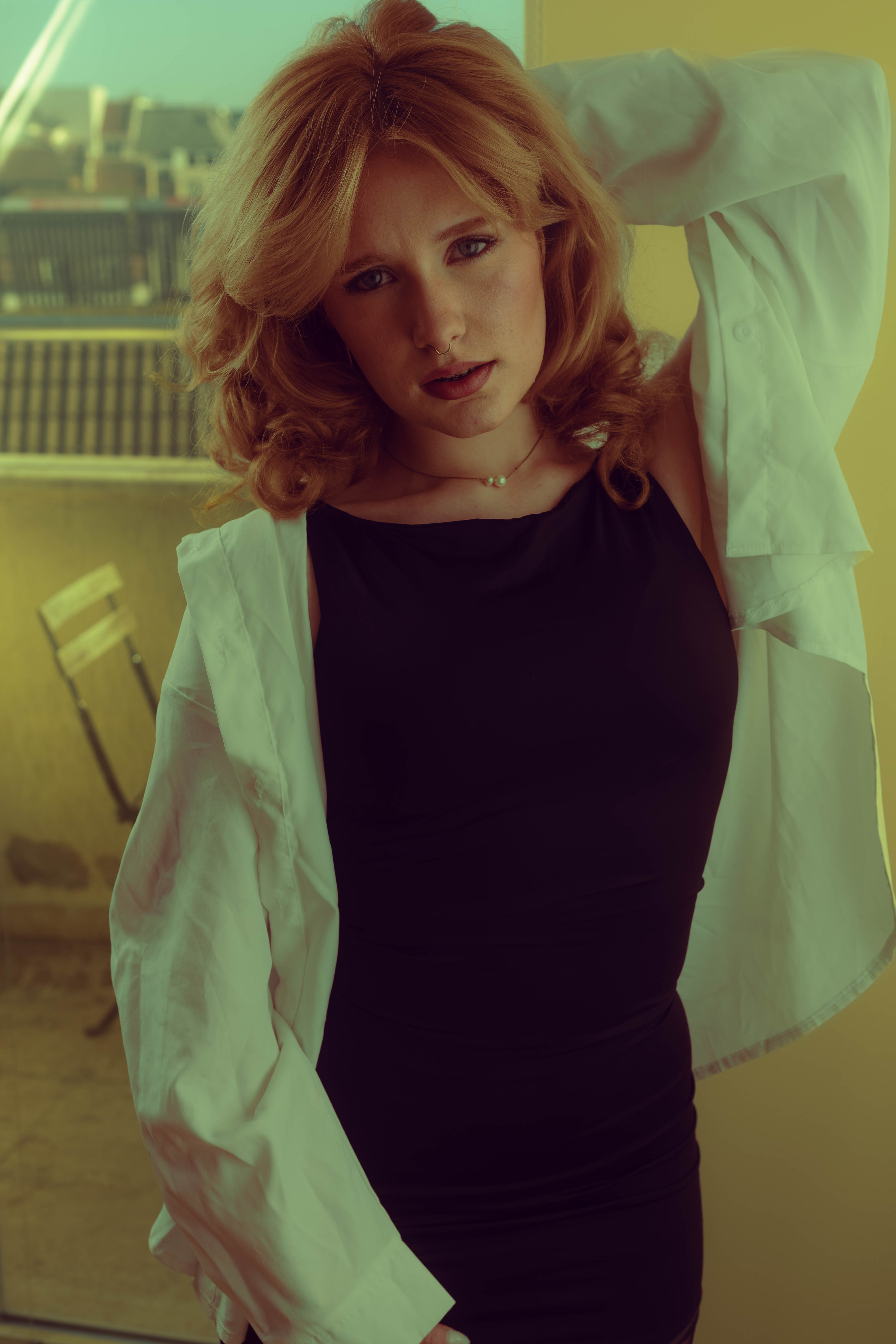 Fashion film, white shirt and black slip, direct gaze, tungsten interior