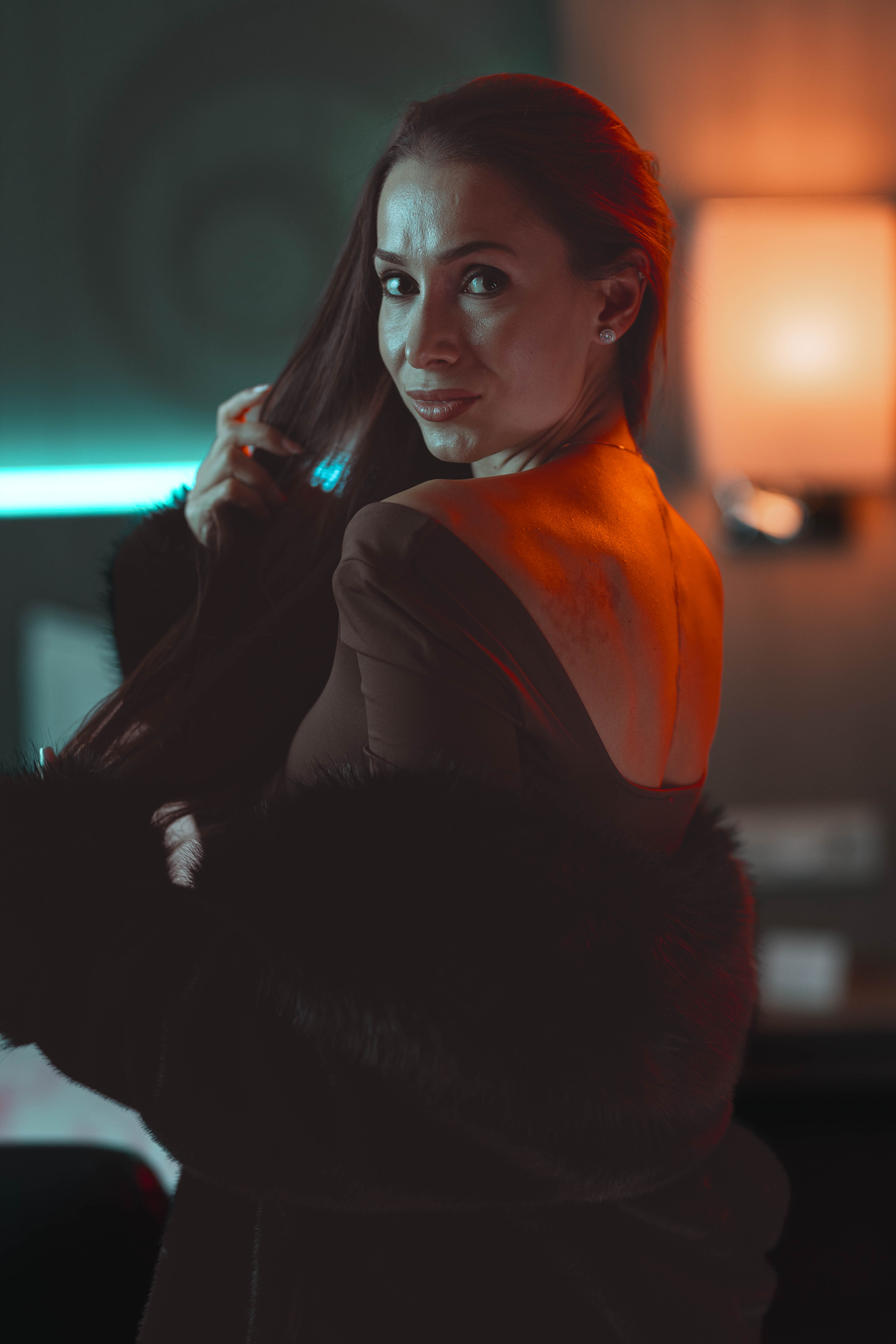 Luxury close portrait, over-shoulder glance, sculpted neon rim