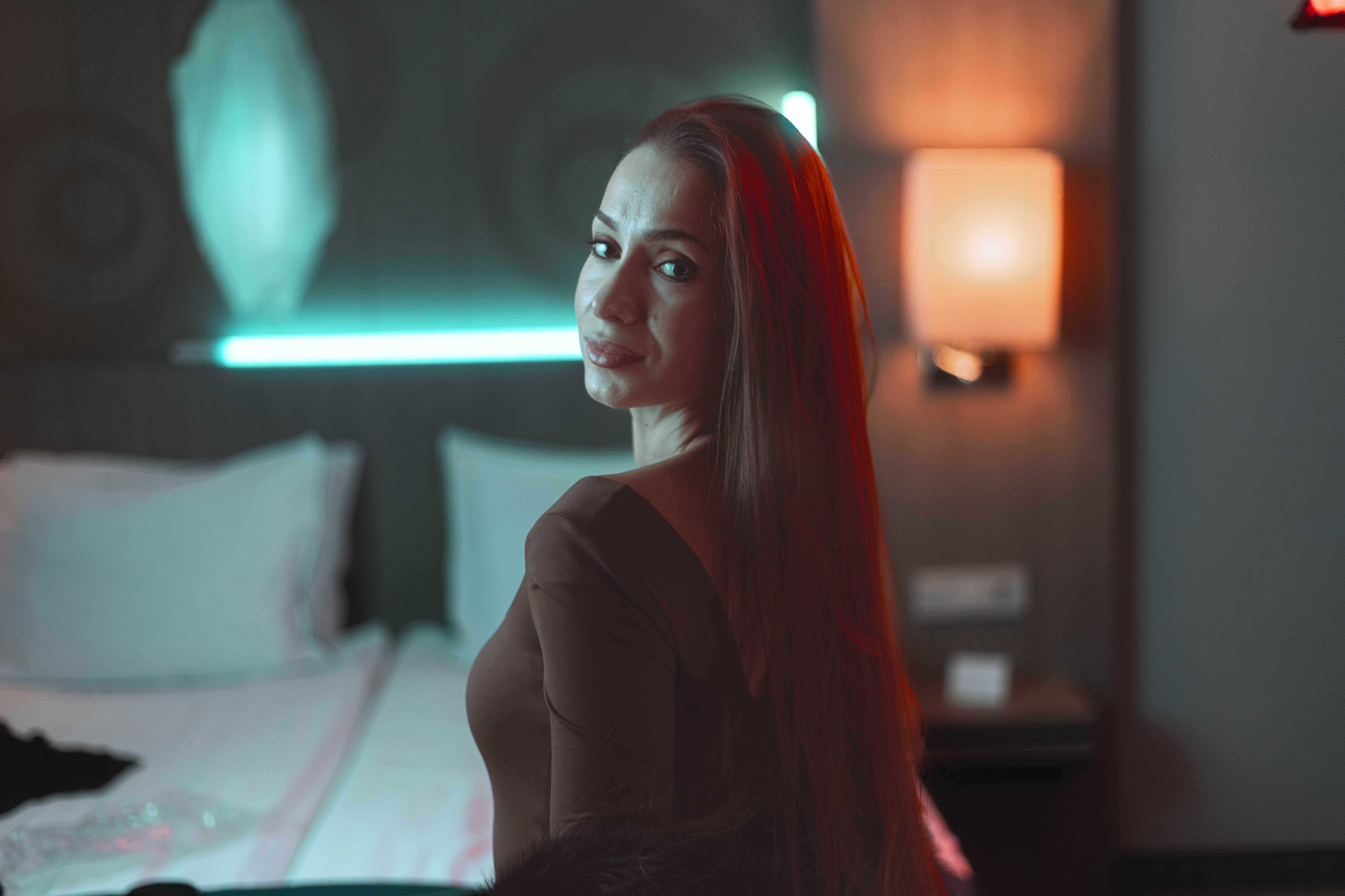 Editorial wide portrait, teal neon and amber lamp duotone, suite atmosphere