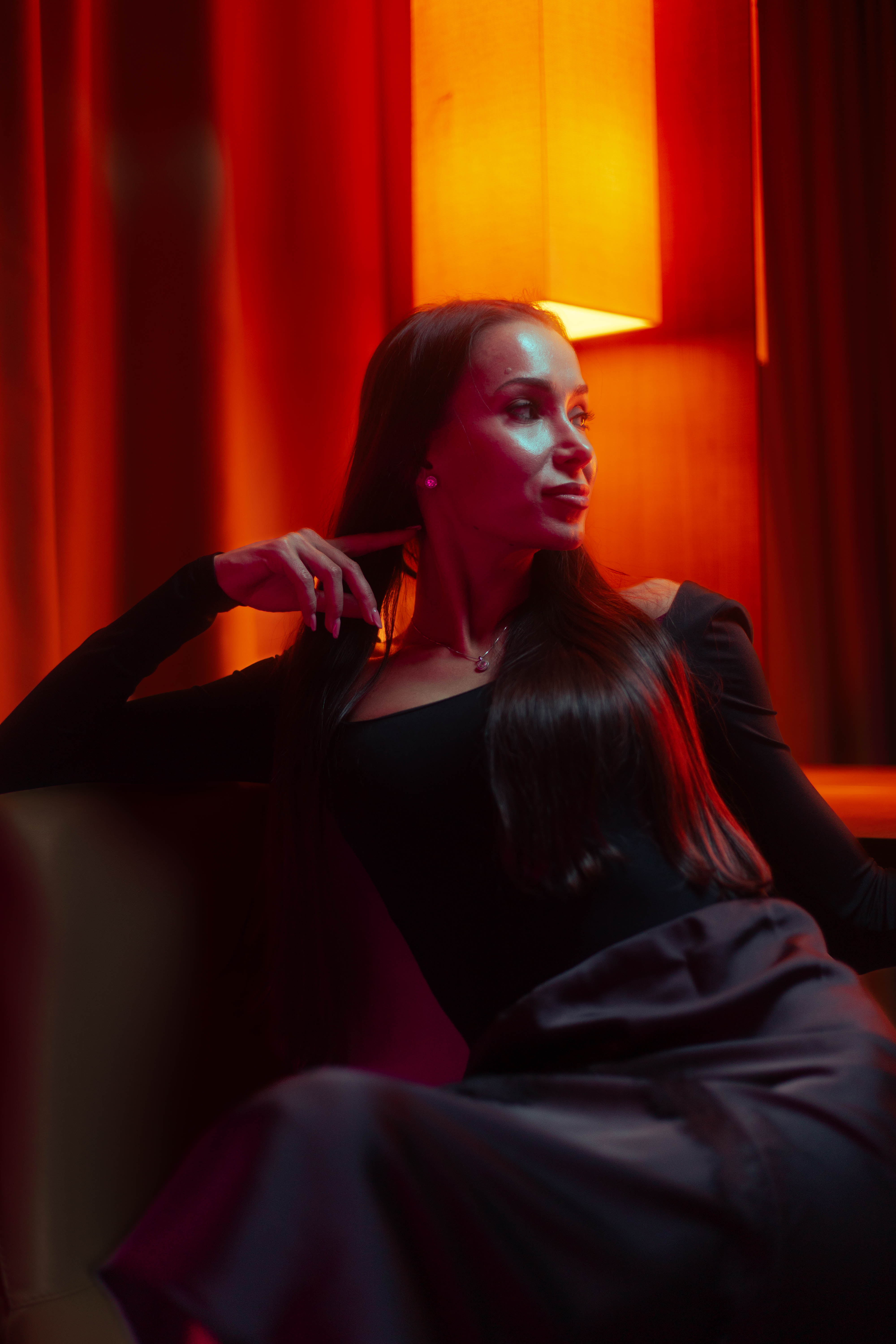 Fashion film still, refined profile under amber lamp halo