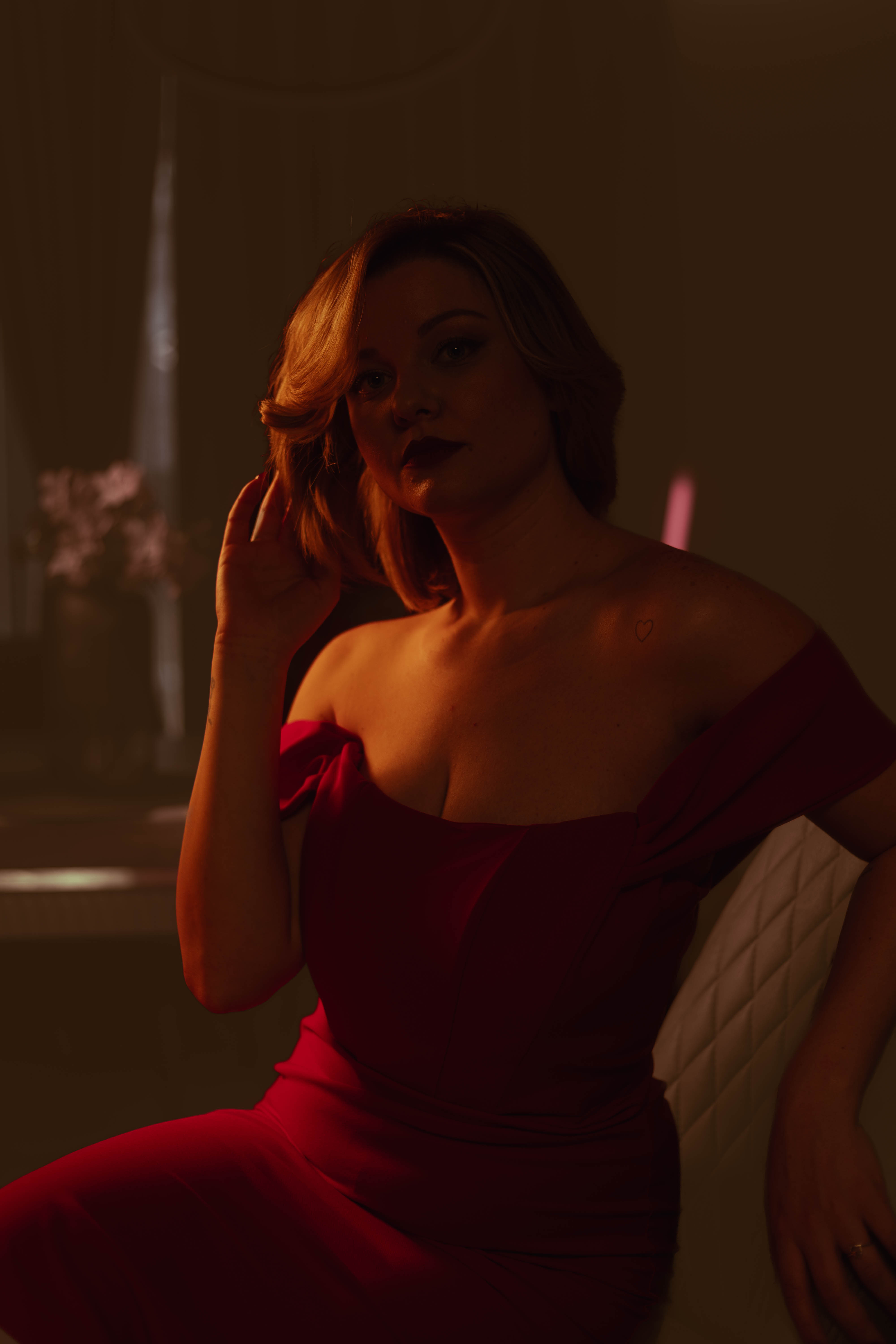 Brand campaign, red dress at handrail, dusk exterior glow