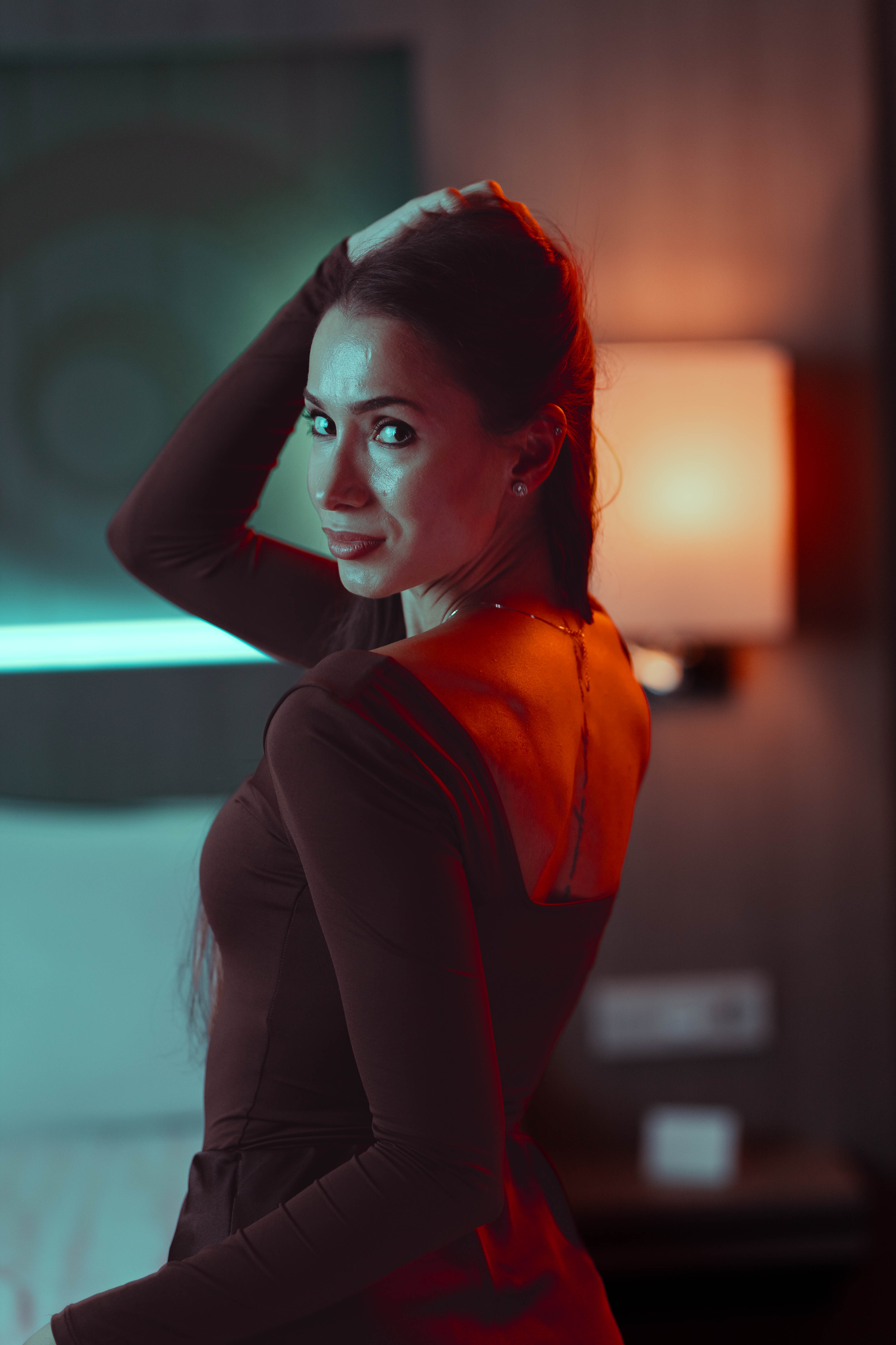 Luxury portrait, over-shoulder glance, teal neon and amber duotone