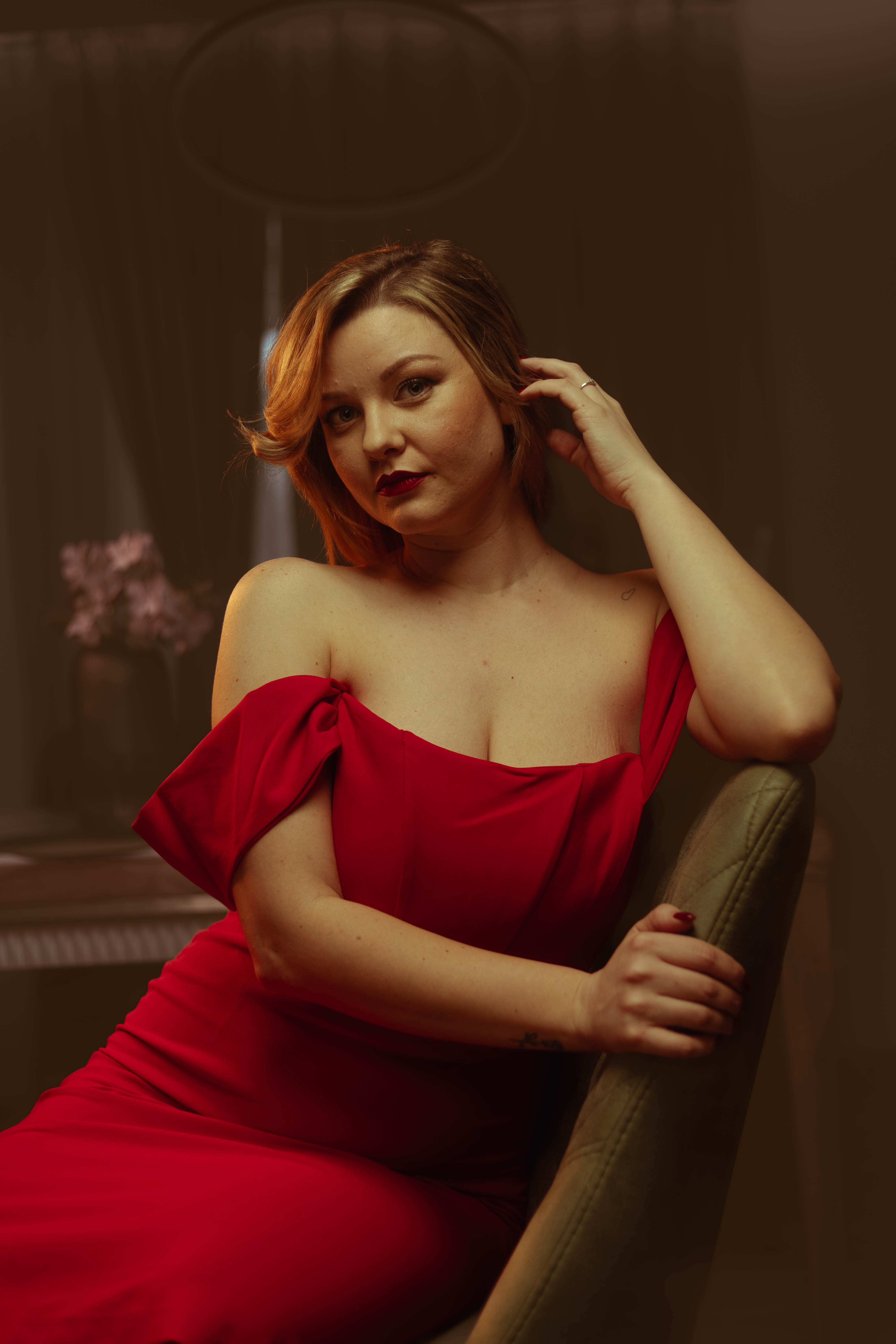 Editorial vintage portrait, crimson dress, upward gaze, warm amber grade