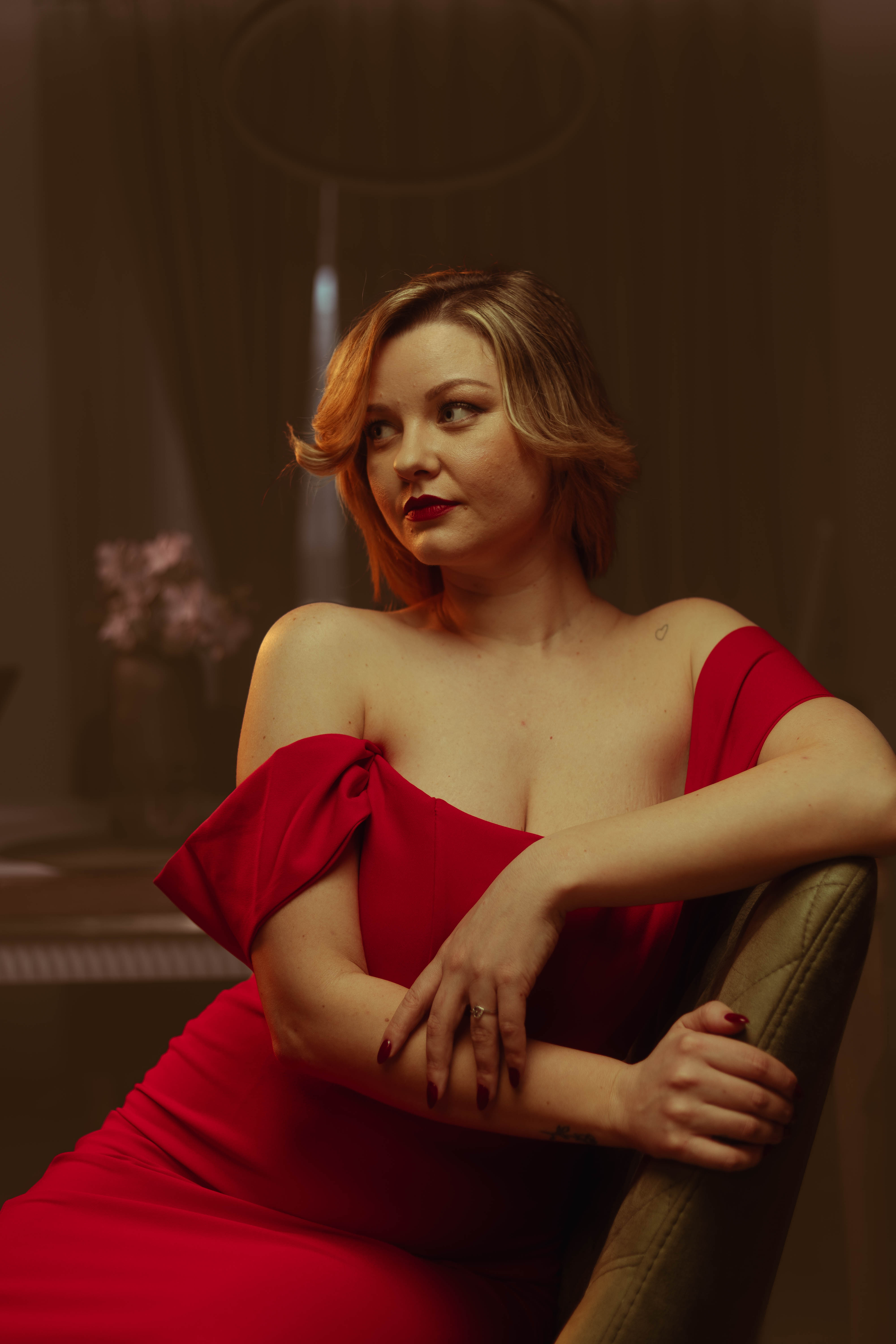 Editorial seated portrait, deep amber wash, vintage cinema mood
