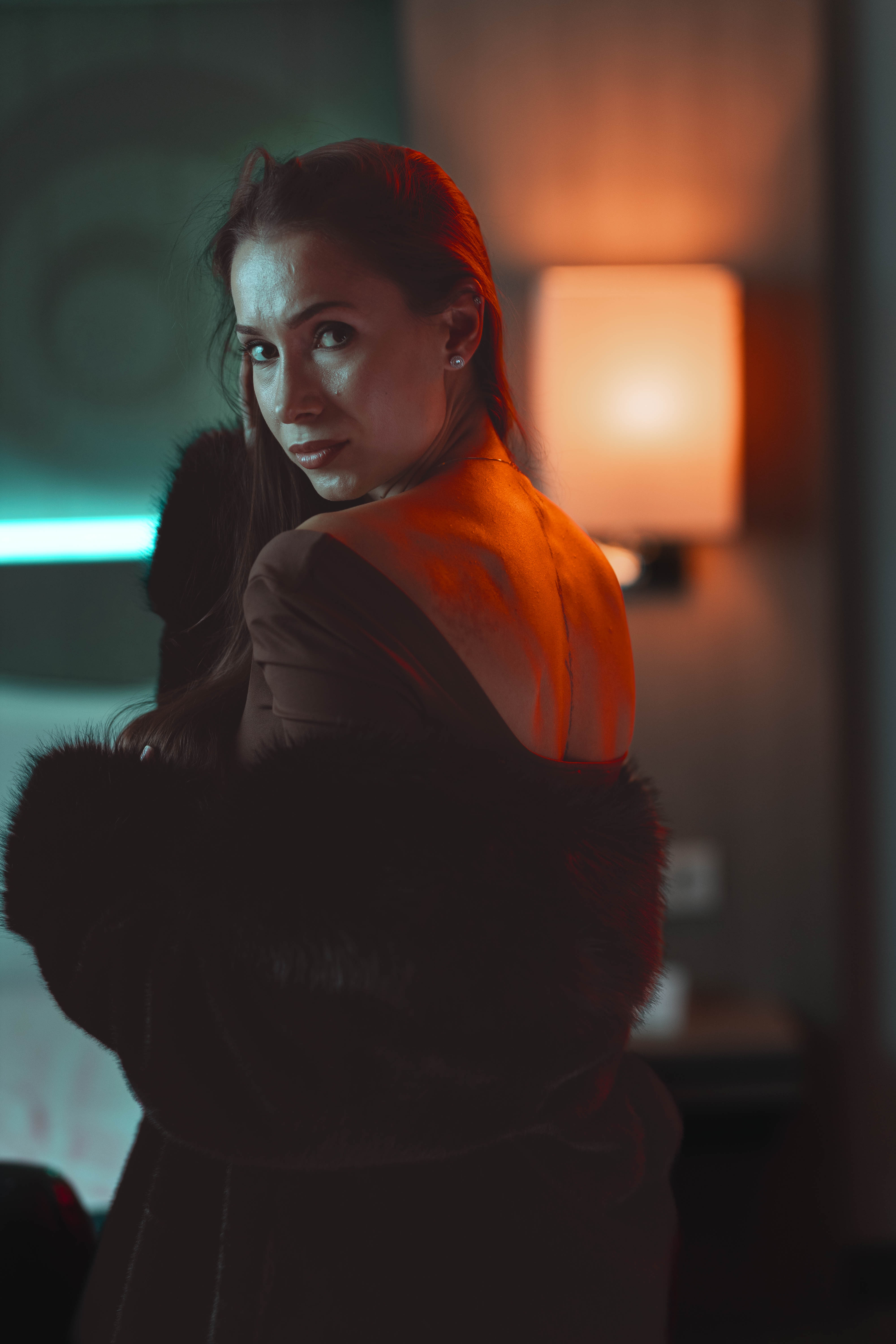 Luxury portrait, sculpted fur silhouette, over-shoulder gaze