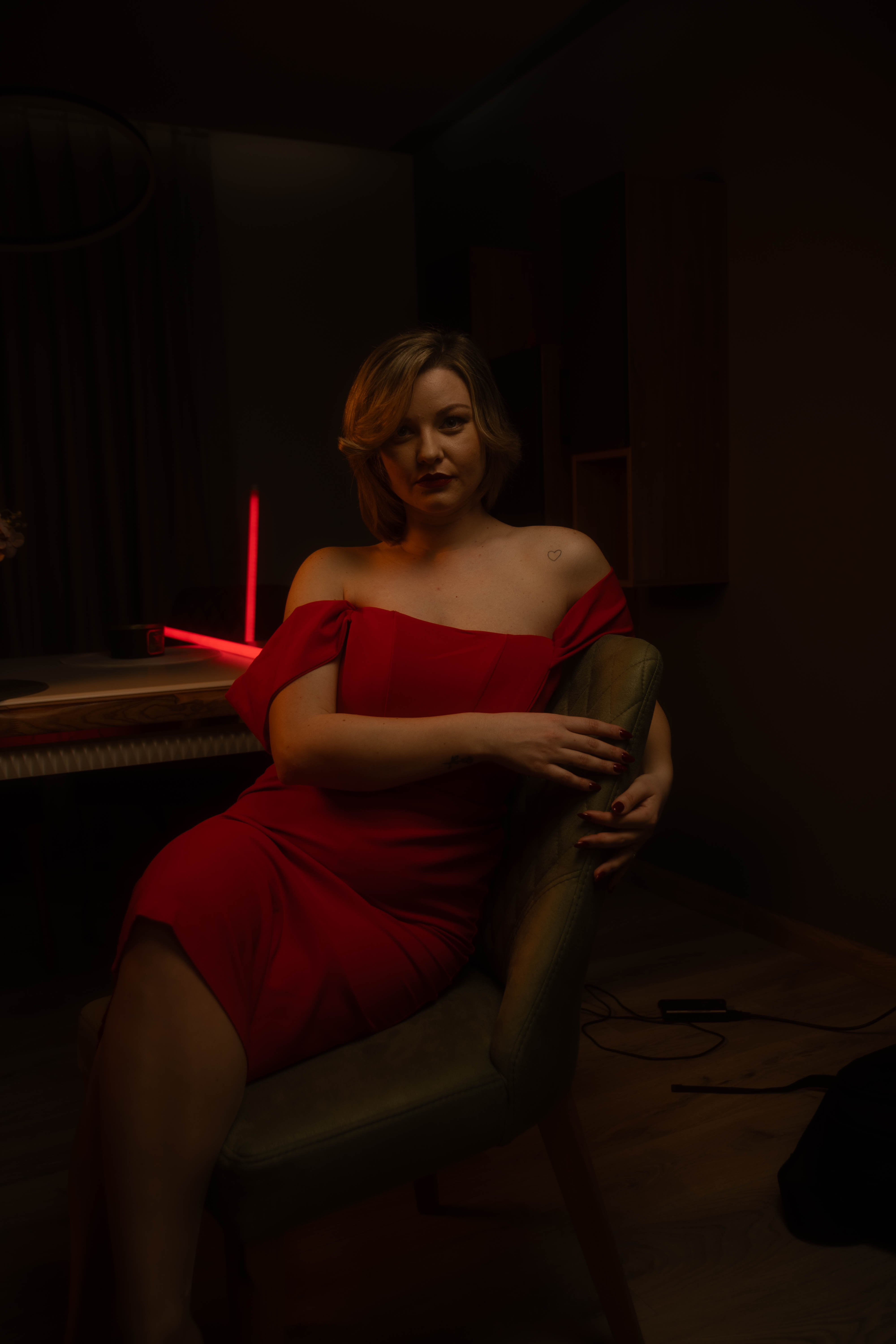 Luxury portrait, red dress, hand-in-hair gesture, warm amber wash