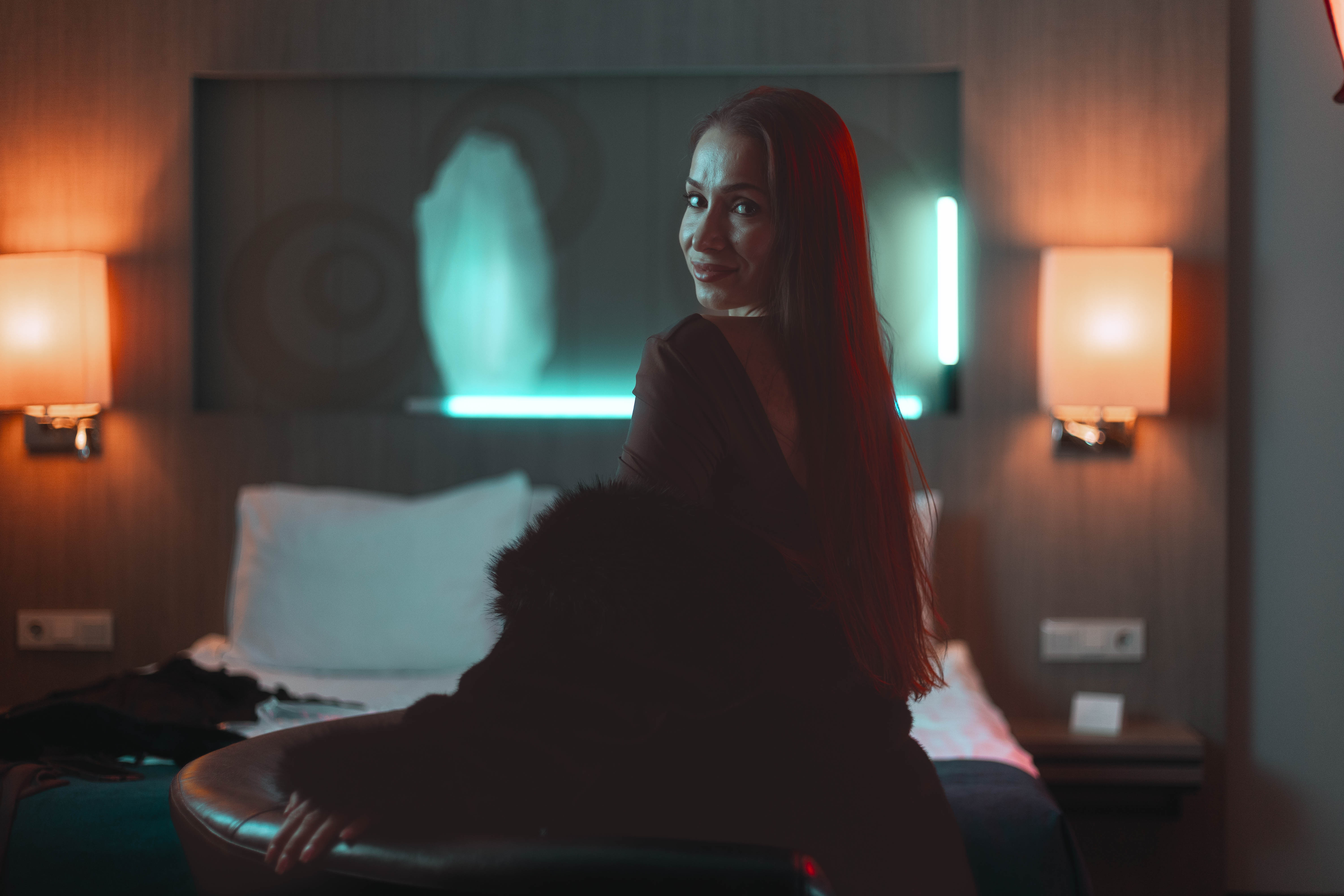 Brand campaign wide, hotel suite context, neon and tungsten ambience