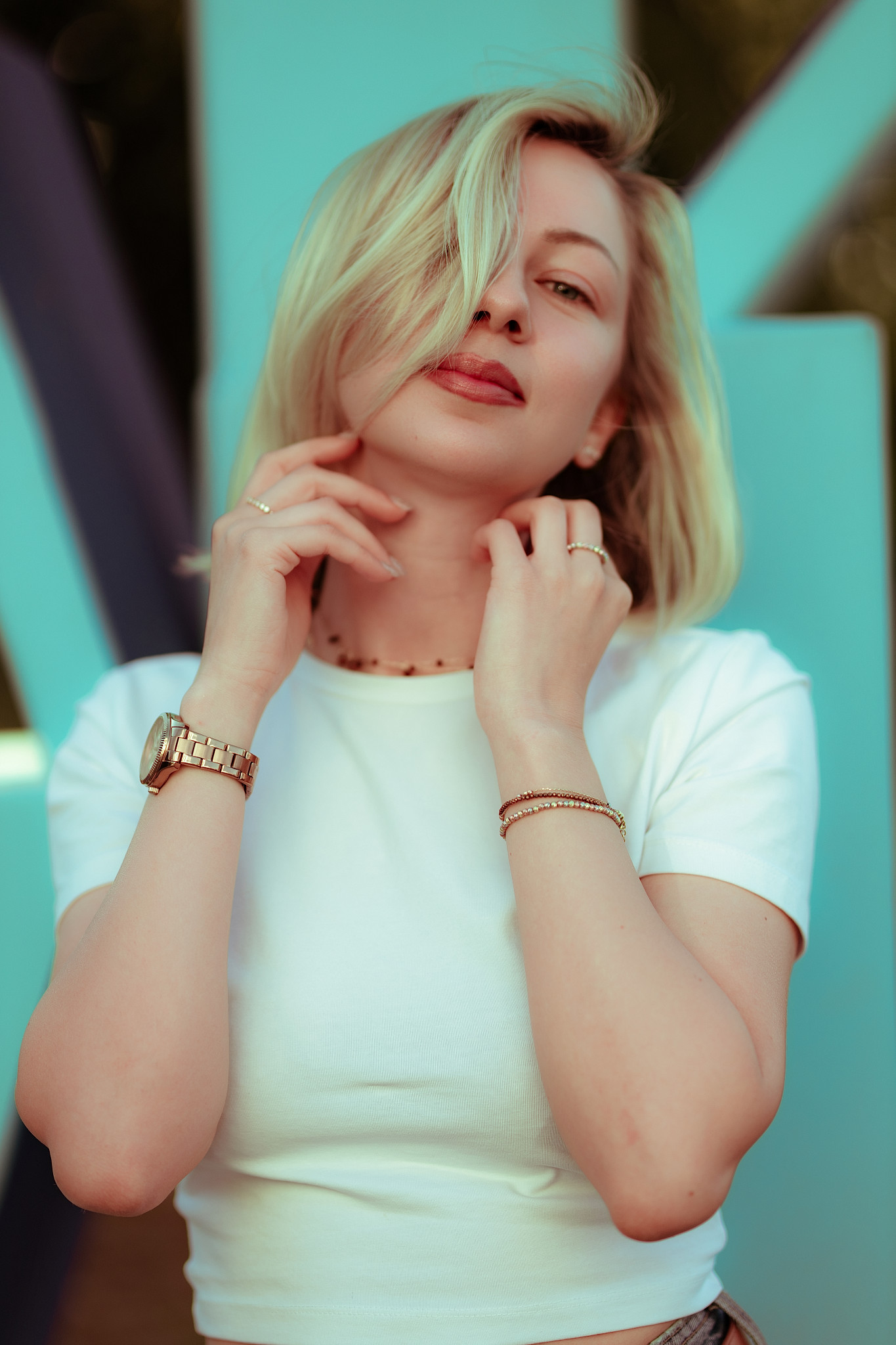 Luxury close portrait, white tee, hand-to-chin, soft teal backdrop