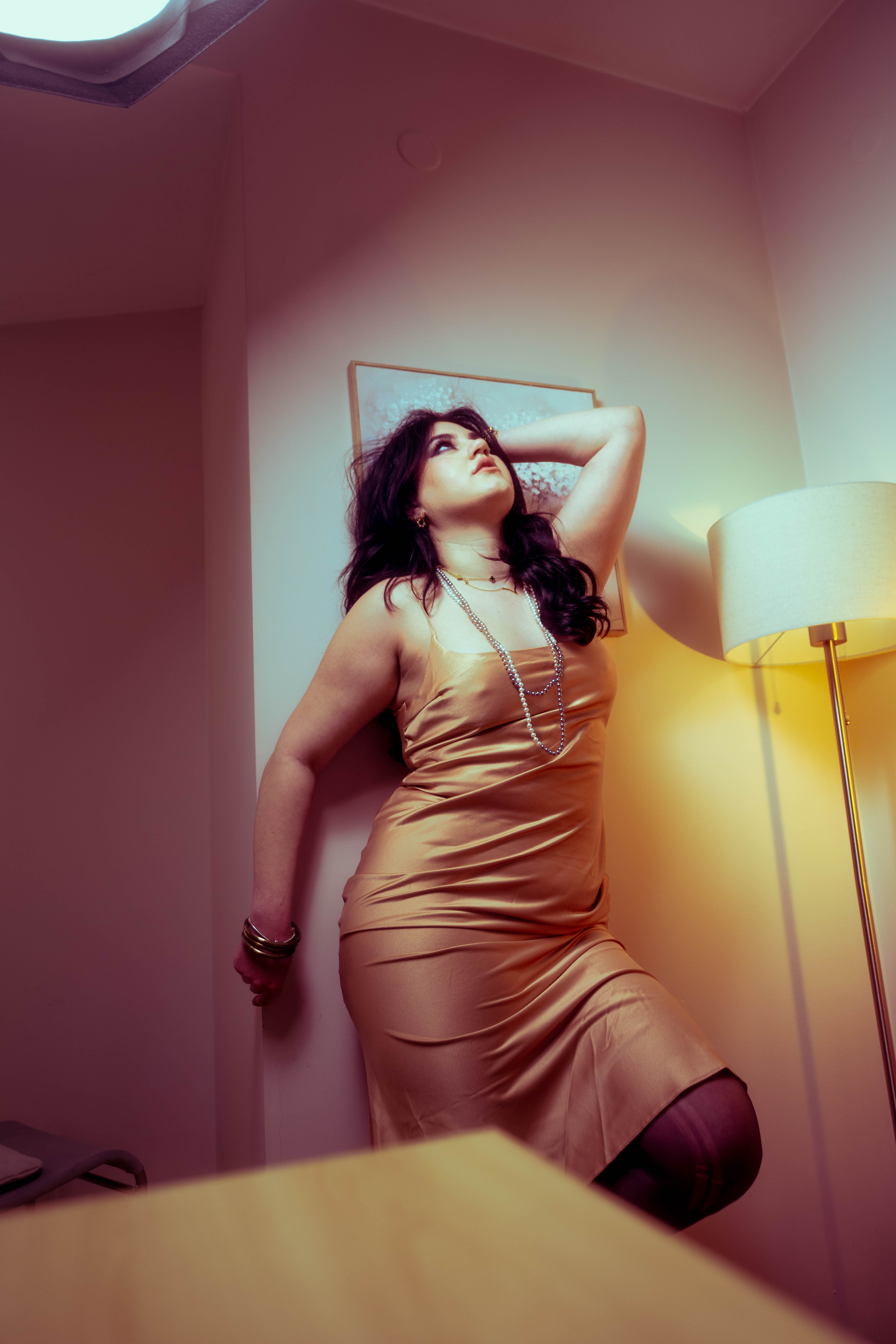 Fashion still, peach satin slip, tungsten lamp glow, hallway elegance